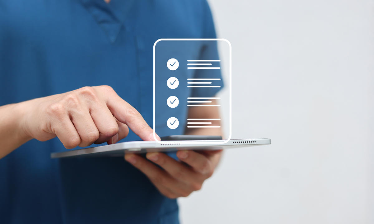 Main tenant une tablette affichant une liste de contrôle numérique avec des coches