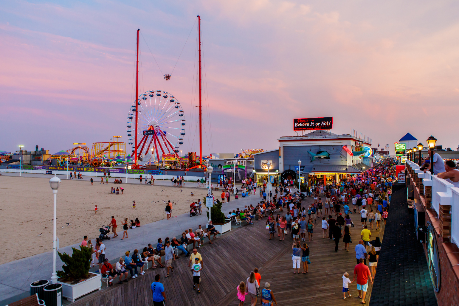 Crépuscule à Ocean City (Maryland) avec le parc d’attractions de la promenade de bois illuminé.