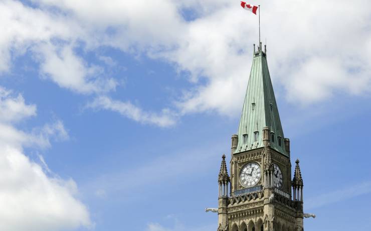 Un drapeau du Canada flotte au-dessus de l'édifice du Parlement à Ottawa.