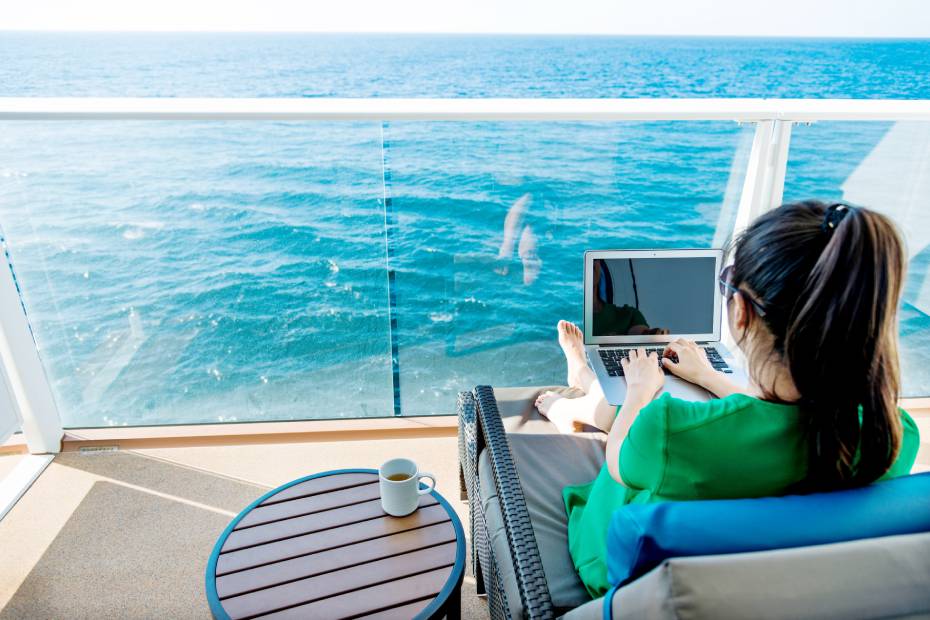 Femme sur un bateau de croisière à l'aide d'un ordinateur portable.