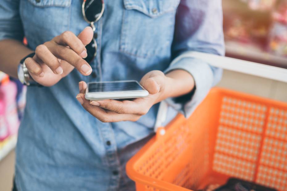 Un homme sur son smartphone dans une épicerie.