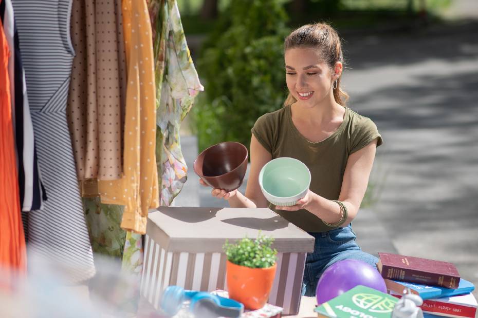 Femme aux cheveux longs tenant des pots vides, essayant de décider lequel convient le mieux