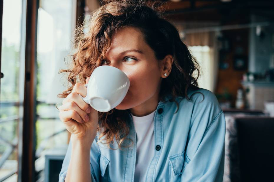 Une photo montrant une femme qui boit du café