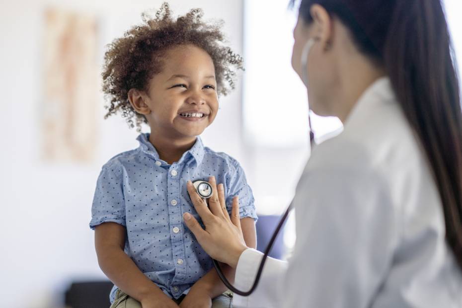Une médecin ausculte le cœur d'un petit garçon.