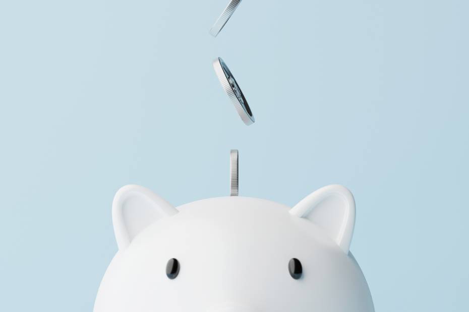 Gros plan d'une tirelire avec des pièces de monnaie qui tombent à l'intérieur.