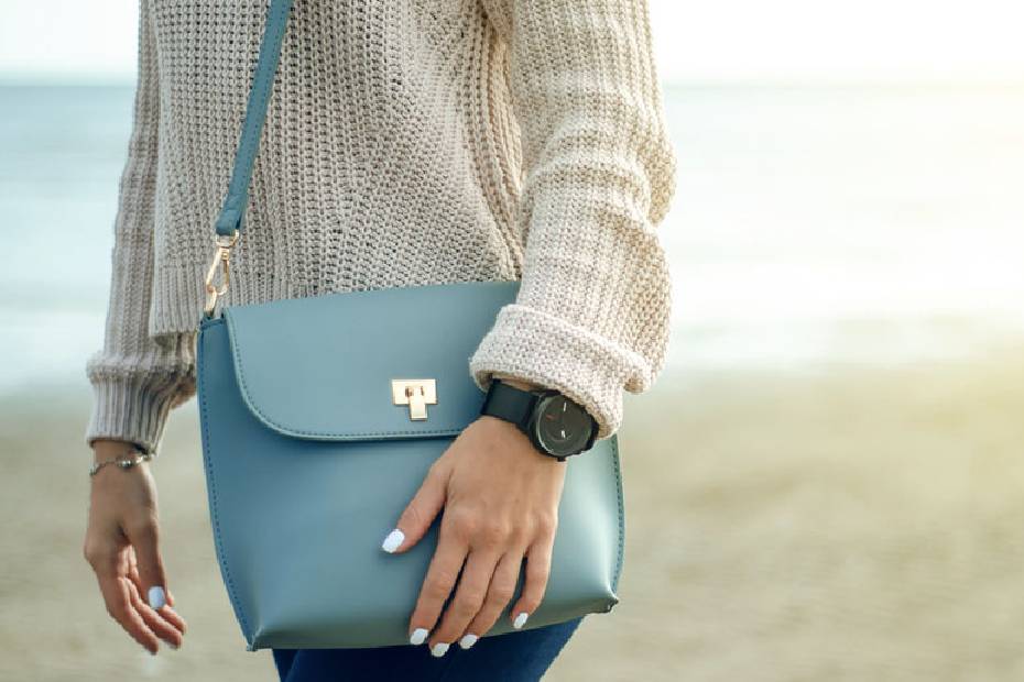 Femme avec la main sur le sac à main.