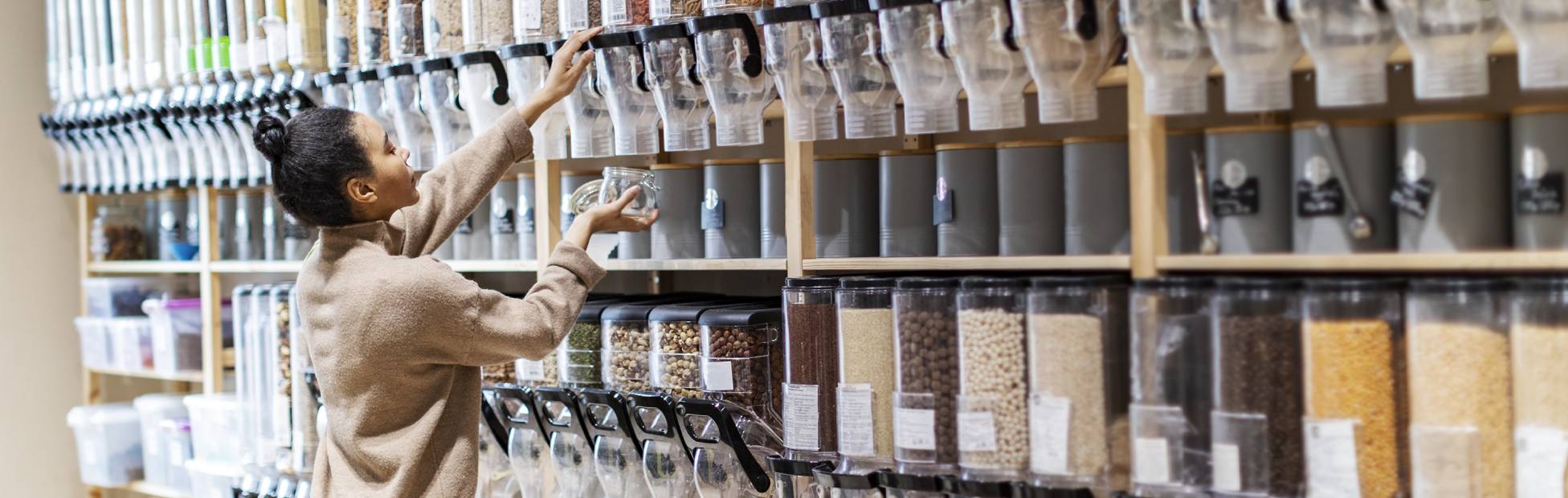 Une jeune cliente a rempli un contenant de haricots secs dans une coopérative.
