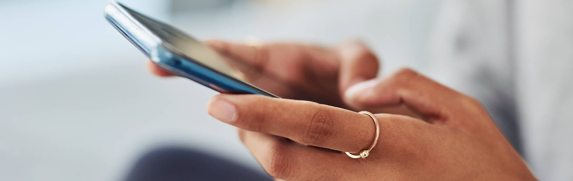 Mains féminines tenant un téléphone portable.