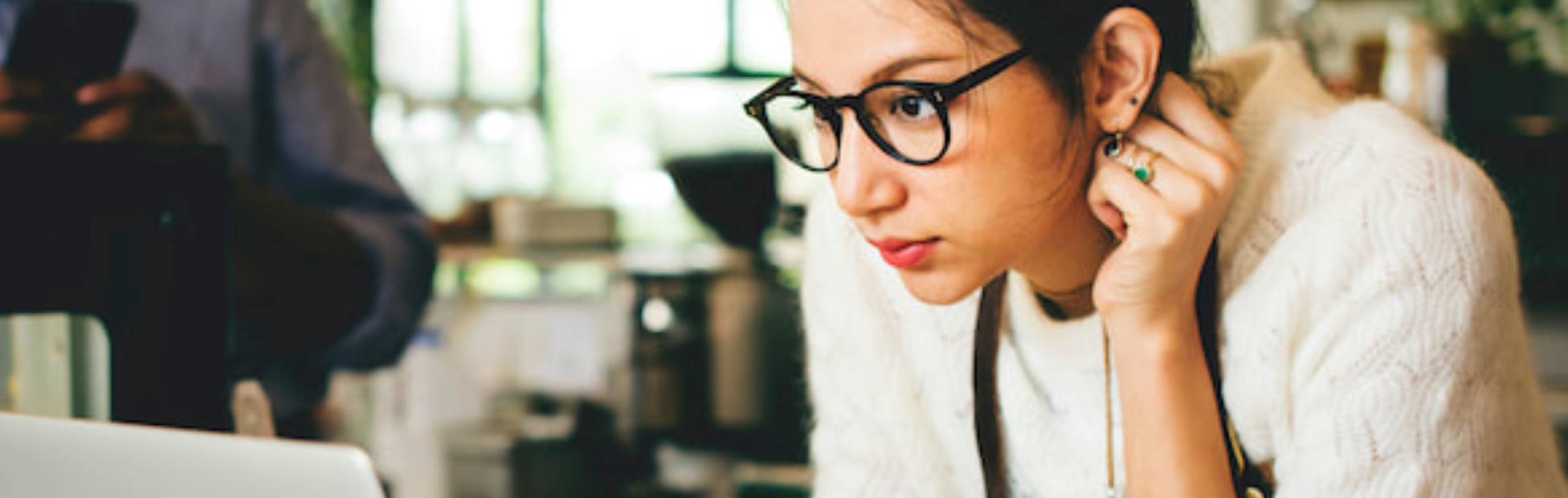 Dame regardant l'écran d'un ordinateur portable dans un café