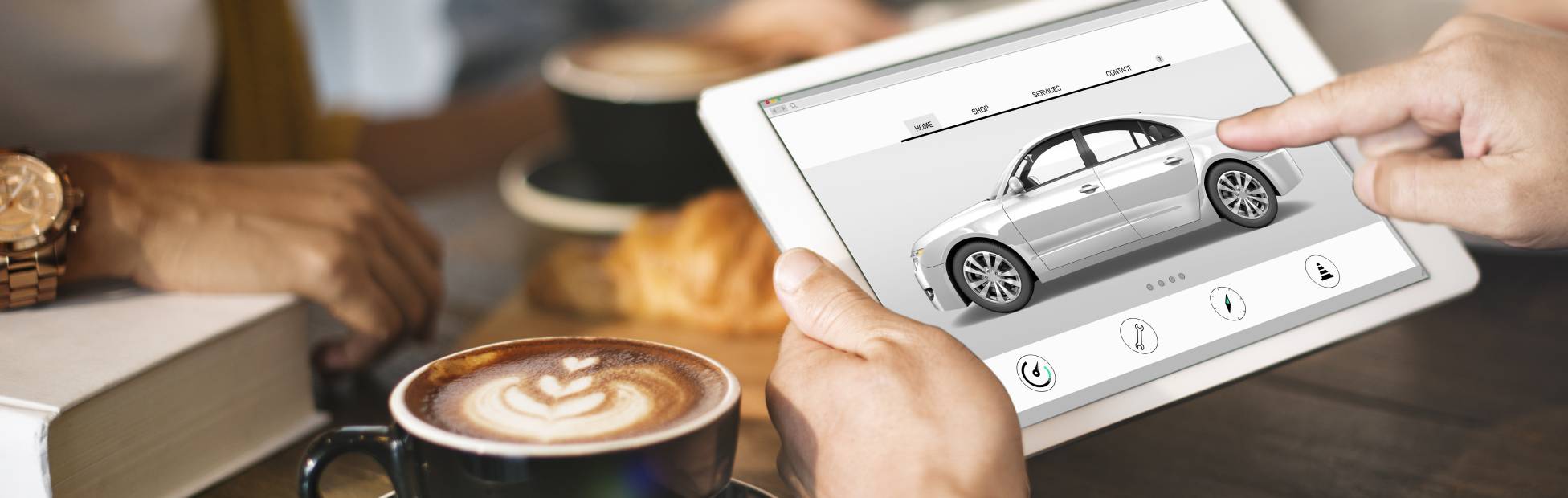 Un chauffeur dans un café, recherchant des véhicules électriques sur une tablette