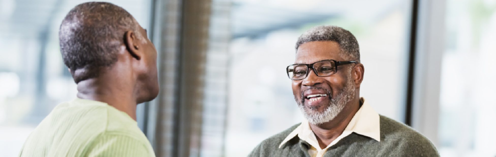Image de deux hommes en train de discuter en prenant un café