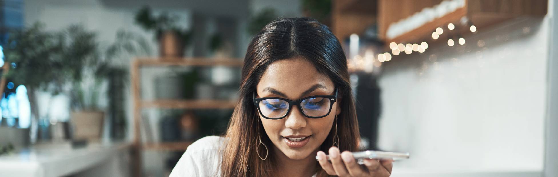 Une jeune femme parle au téléphone en prenant des notes.
