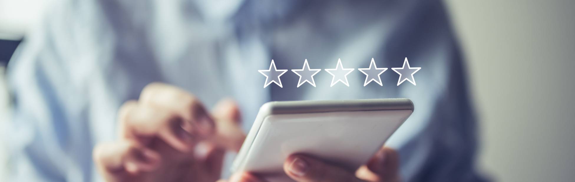 Un jeune propriétaire d'entreprise sur son téléphone en ajoutant un avis 5 étoiles sur un marché virtuel