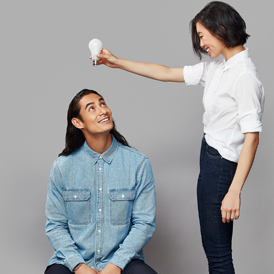 Une dame tenant une ampoule au-dessus d'une tête d'homme