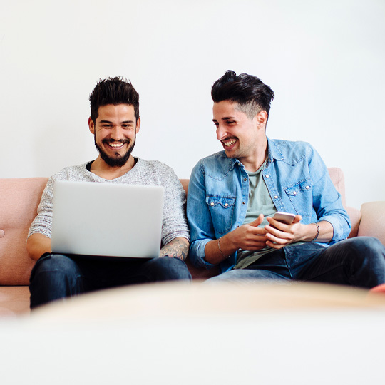 Amis assis sur un canapé avec des appareils