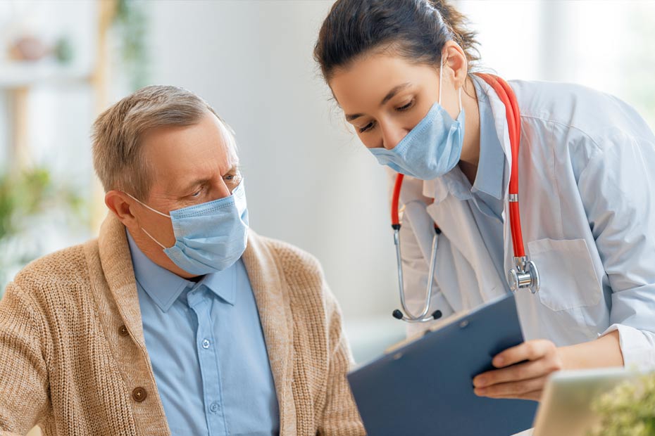 Une gériatre donne des renseignements à un patient âgé.