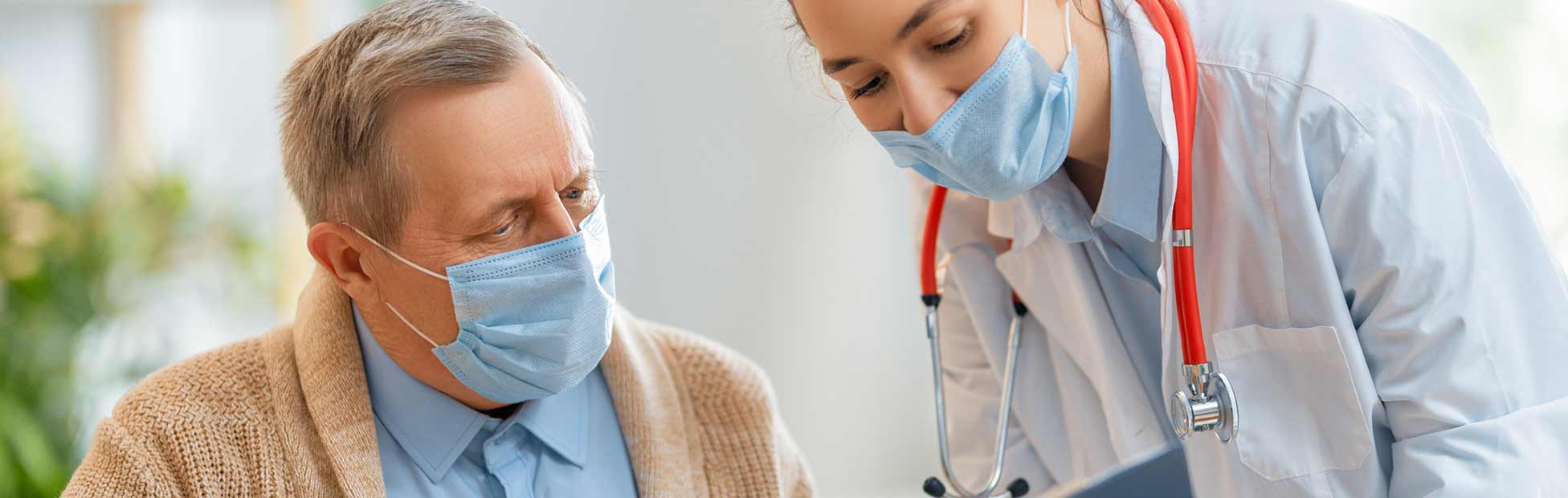 Une gériatre donne des renseignements à un patient âgé.