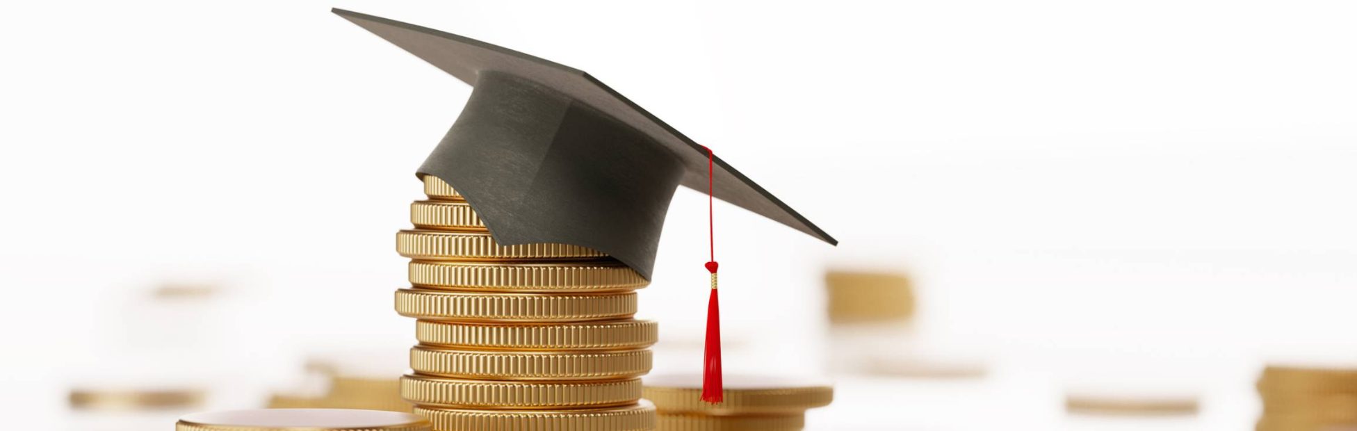 Pile de pièces d’or avec un chapeau de graduation sur le dessus de la pile