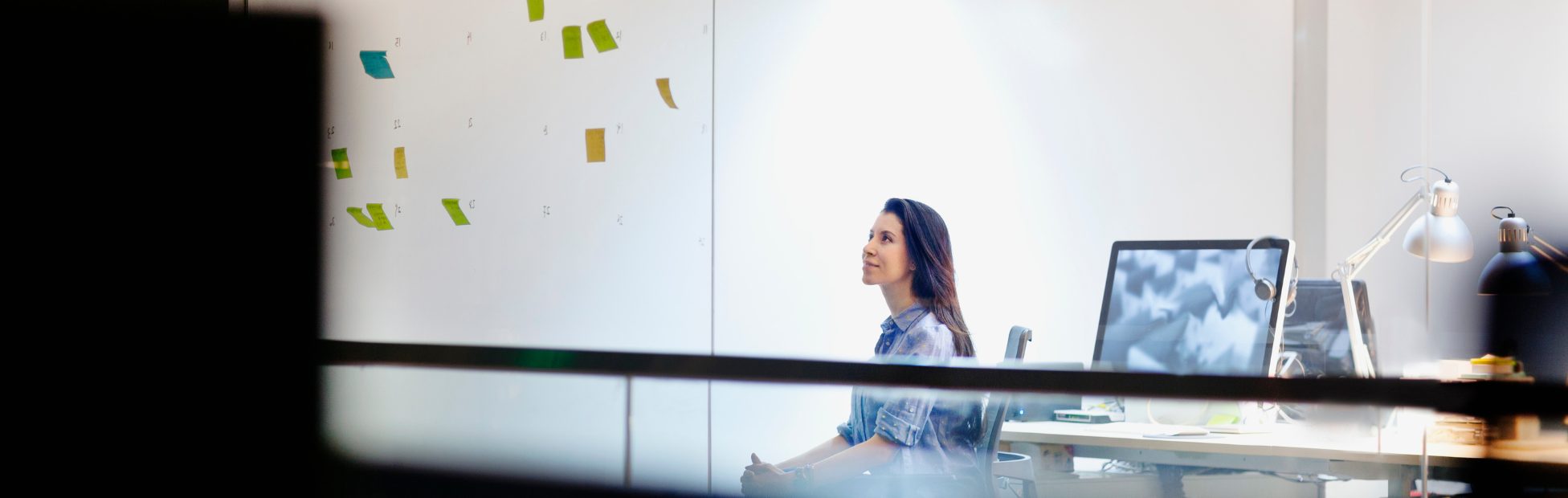Femme dans un bureau regardant des notes autocollantes