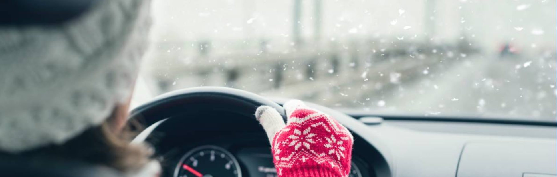 Femme portant un chapeau et des gants de laine se déplaçant en VE tandis qu’il neige à l’extérieur