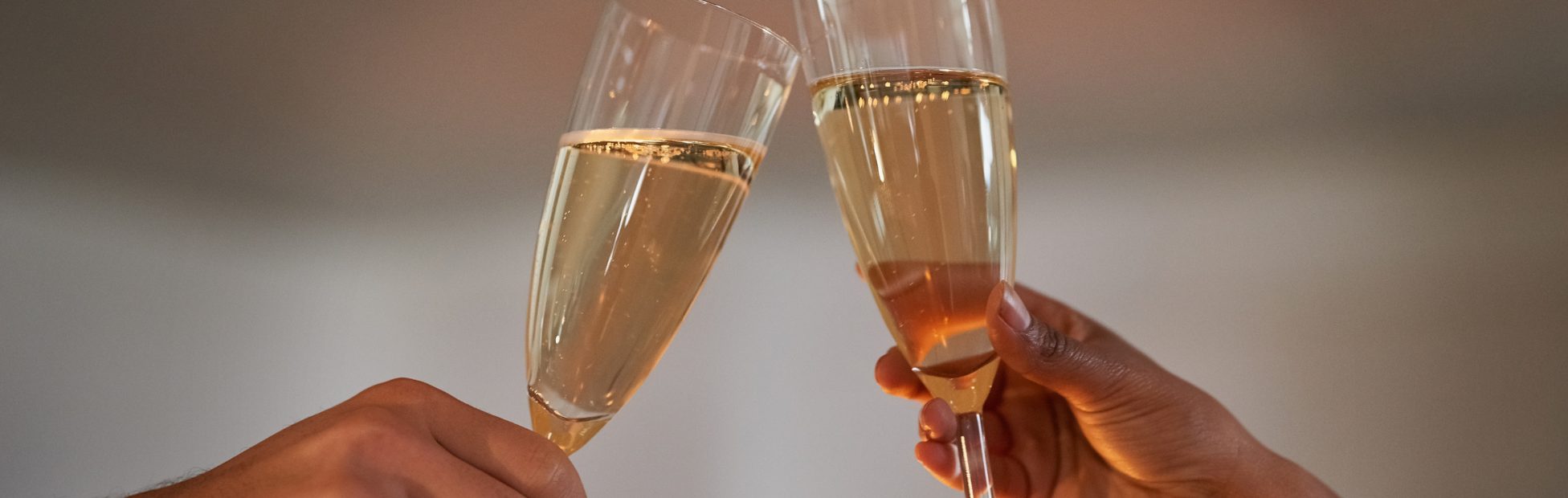 Mains d'un couple qui lève leur flûte de champagne