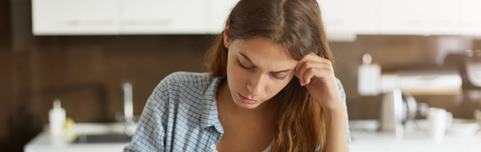 Femme attablée à un bureau, stressée par ses finances
