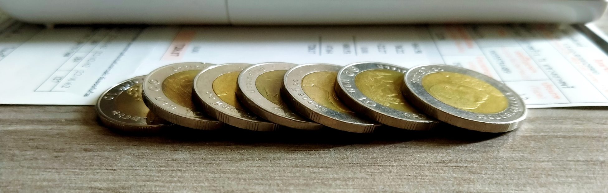 Sept pièces de 2 $ en ligne devant un budget et une calculatrice