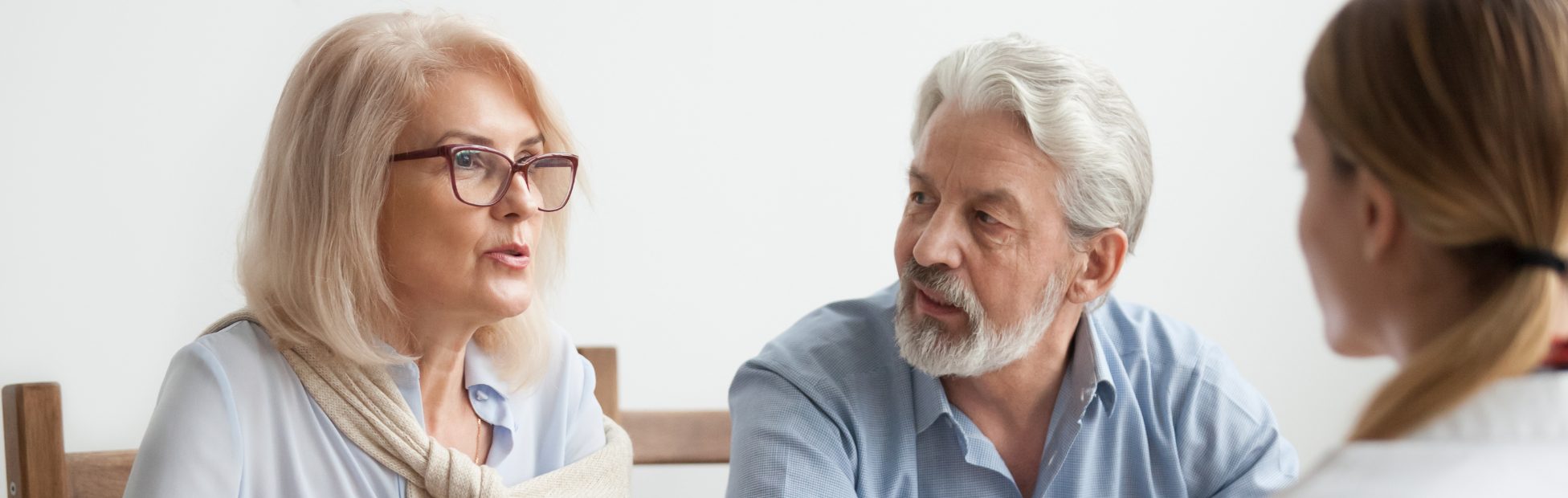 Un couple d'aînés discute de plans de rénovation avec un conseiller.