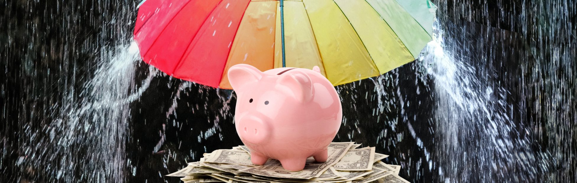 Tirelire rose protégée de la pluie par un parapluie coloré