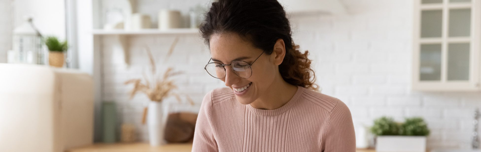 Jeune femme souriante à la maison avec des documents financiers et une calculatrice