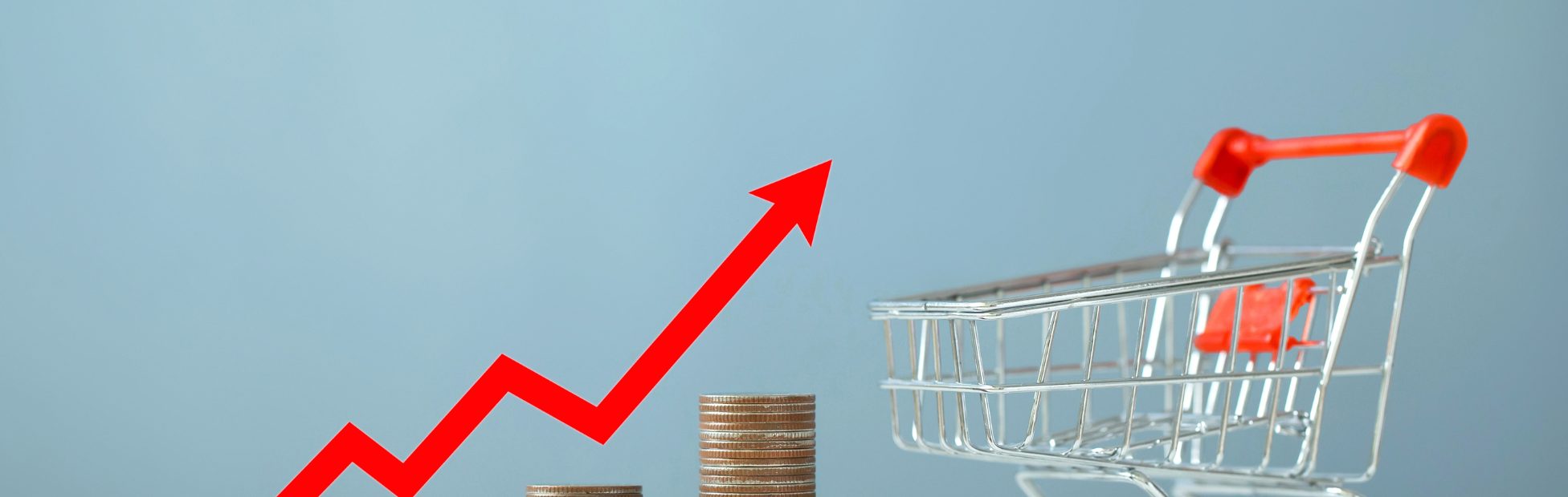 Flèche rouge représentant l'inflation s'élevant à côté d'un panier d'épicerie miniature