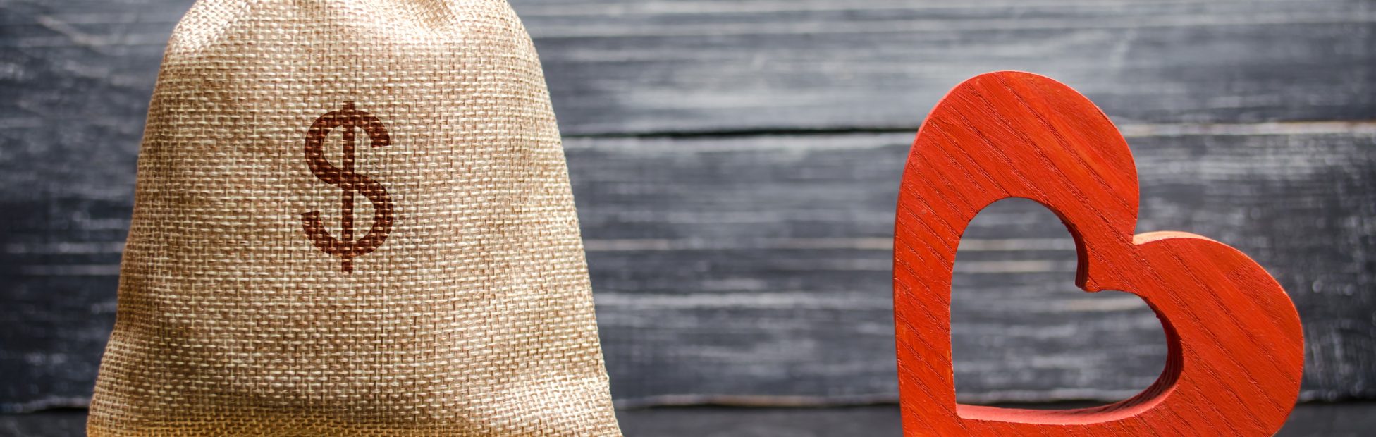Balance avec un cœur brisé d'un côté et un sac d'argent de l'autre.