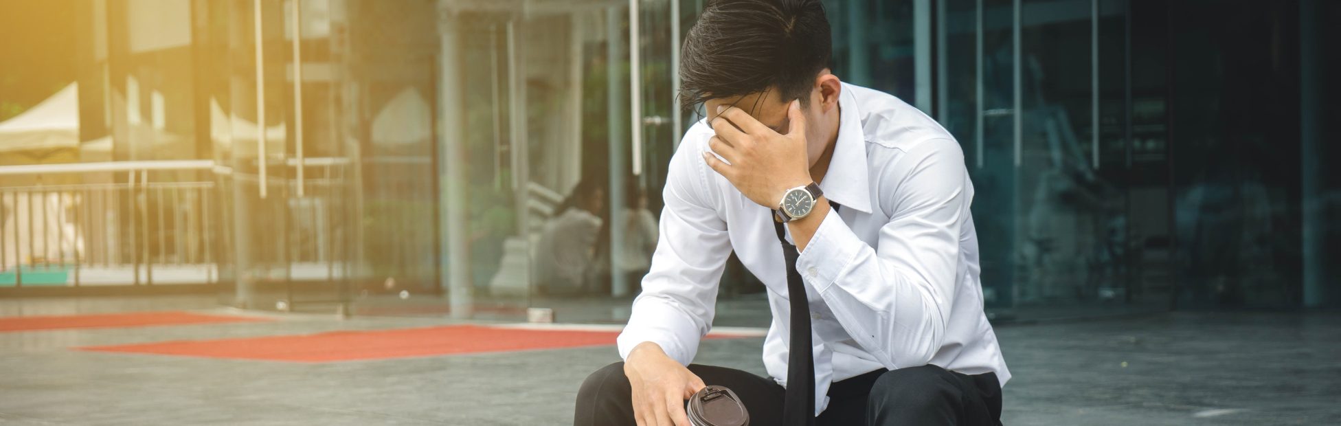 Homme d'affaires au chômage, stressé, assis sur des marches devant son bureau