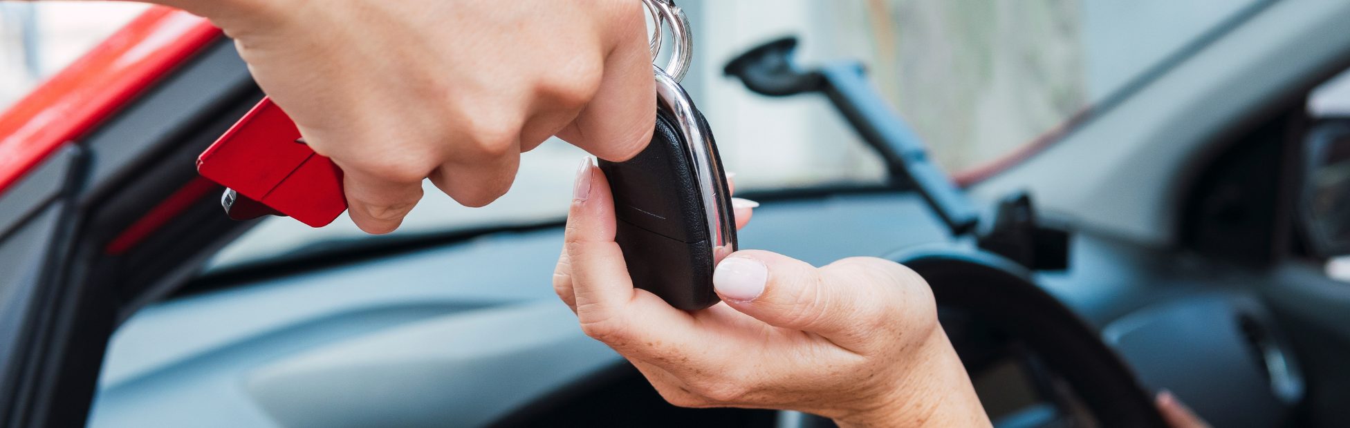 Jeune brunette souriante qui reçoit les clés de sa voiture neuve