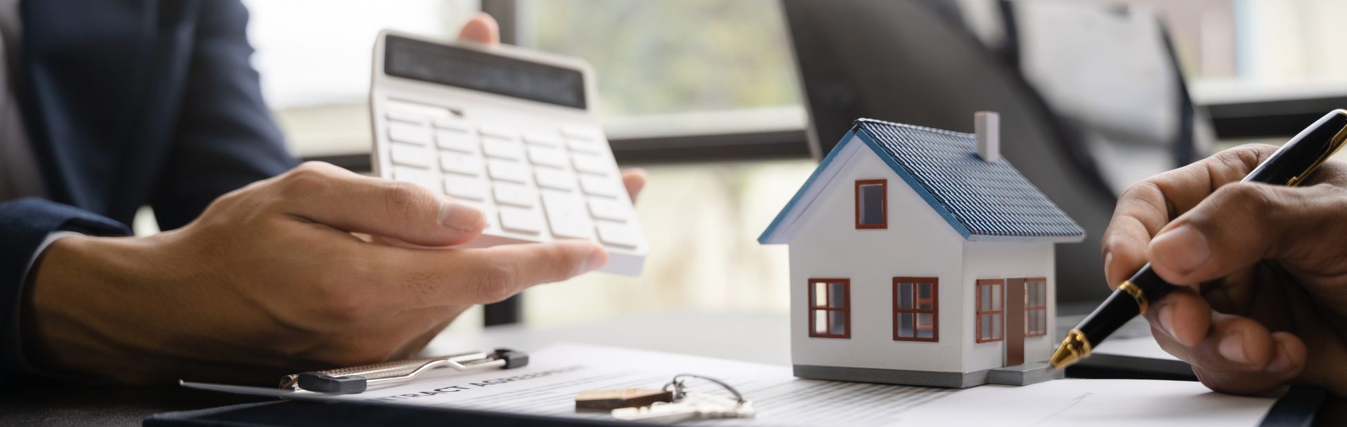 Courtier immobilier et son client examinant des chiffres sur une calculatrice