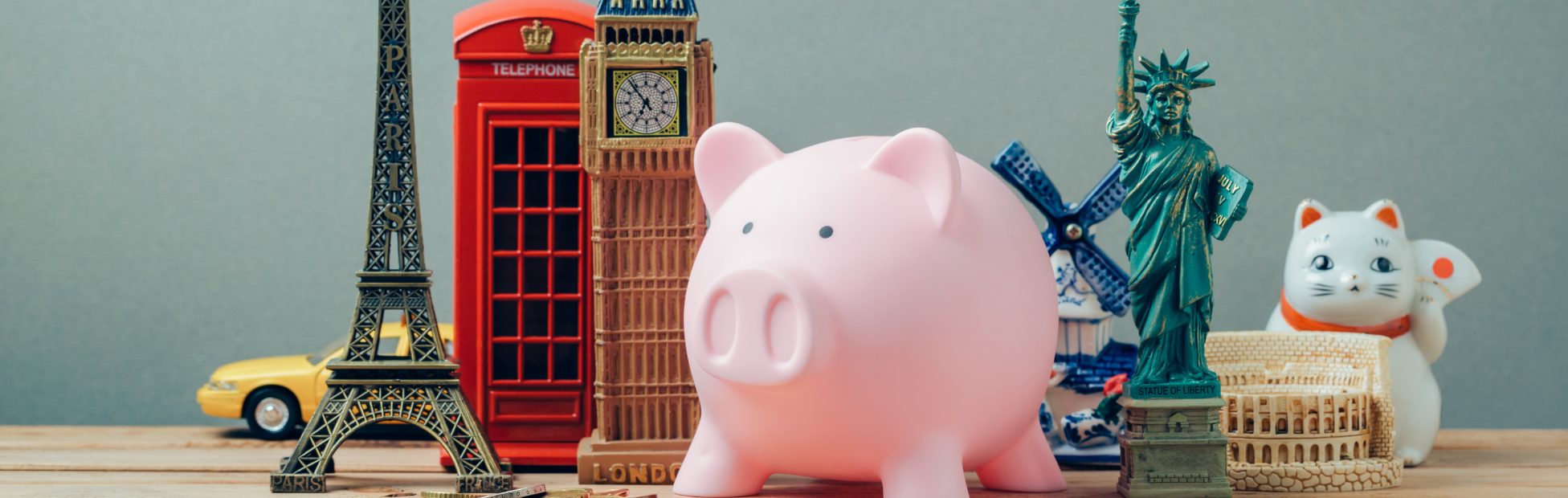 Table avec des figurines de Big Ben, de la tour Eiffel et de la statue de la liberté ainsi qu'une tirelire
