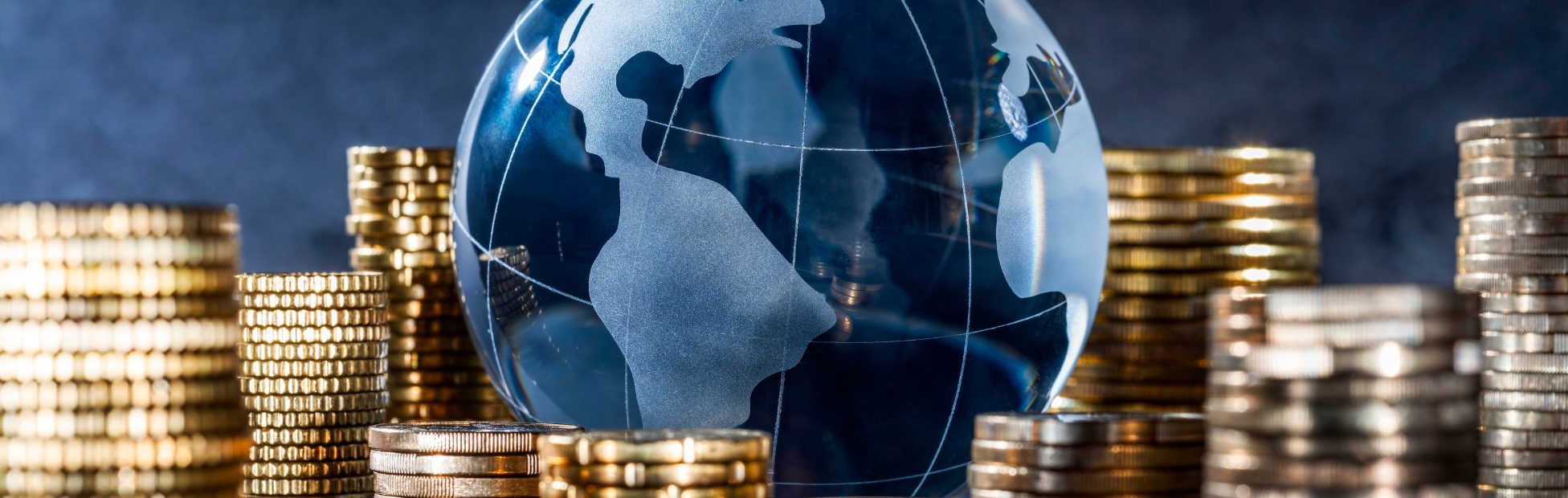 Un globe de verre entouré d'une pile de pièces.