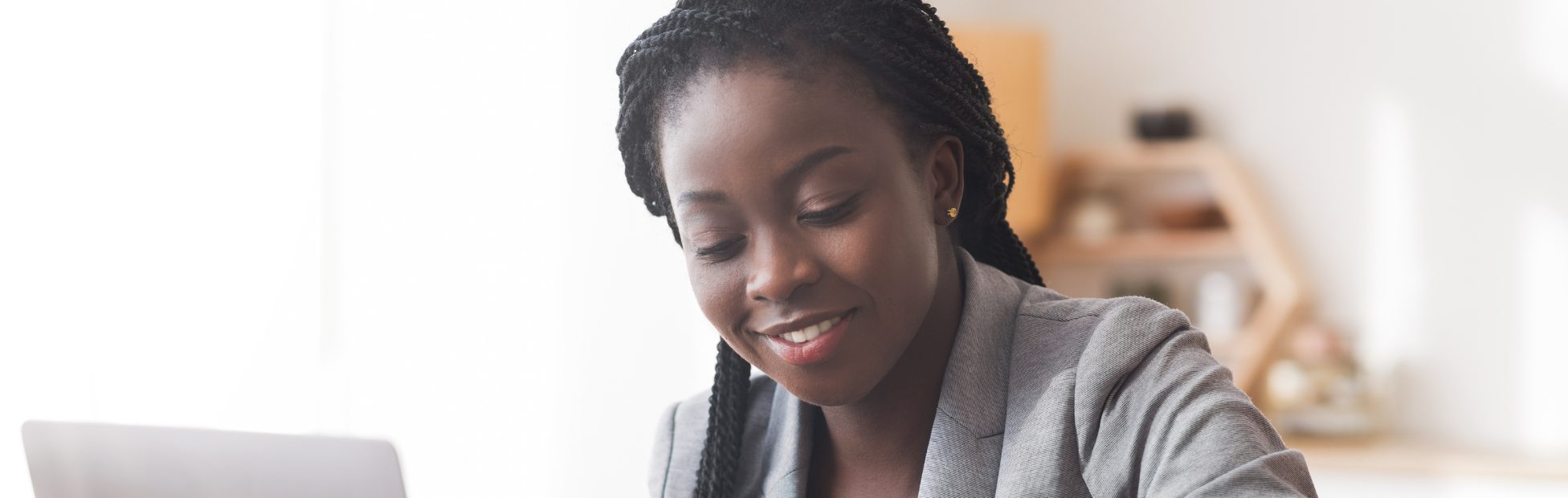 Une entrepreneure noire examine ses finances sur un ordinateur.