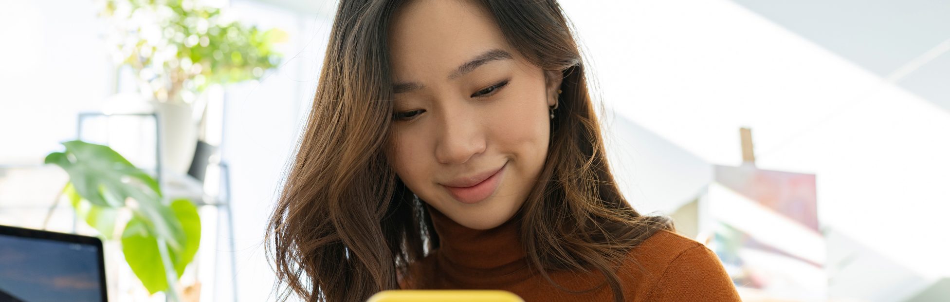 Jeune femme asiatique magasinant en ligne avec son téléphone mobile