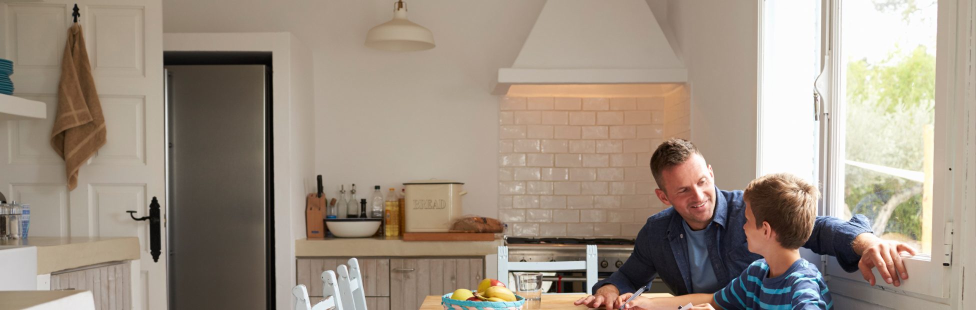 Père et fils assis dans leur cuisine nouvellement rénovée