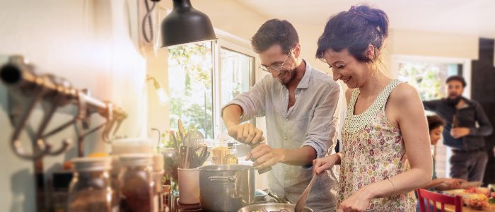Un groupe mixte d'amis s'amuse en préparant un repas dans la cuisine