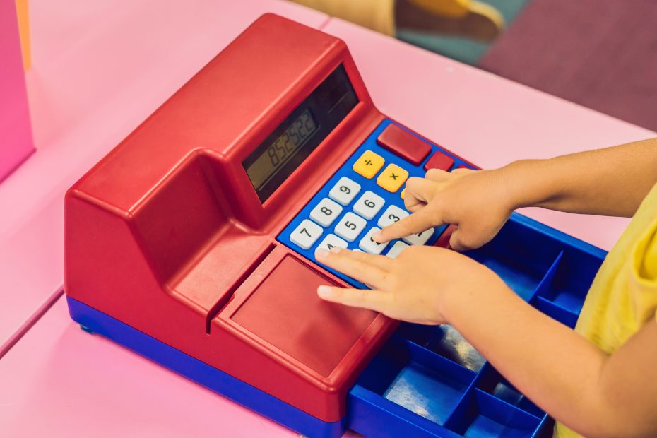 enfant jouant avec une caisse enregistreuse jouet