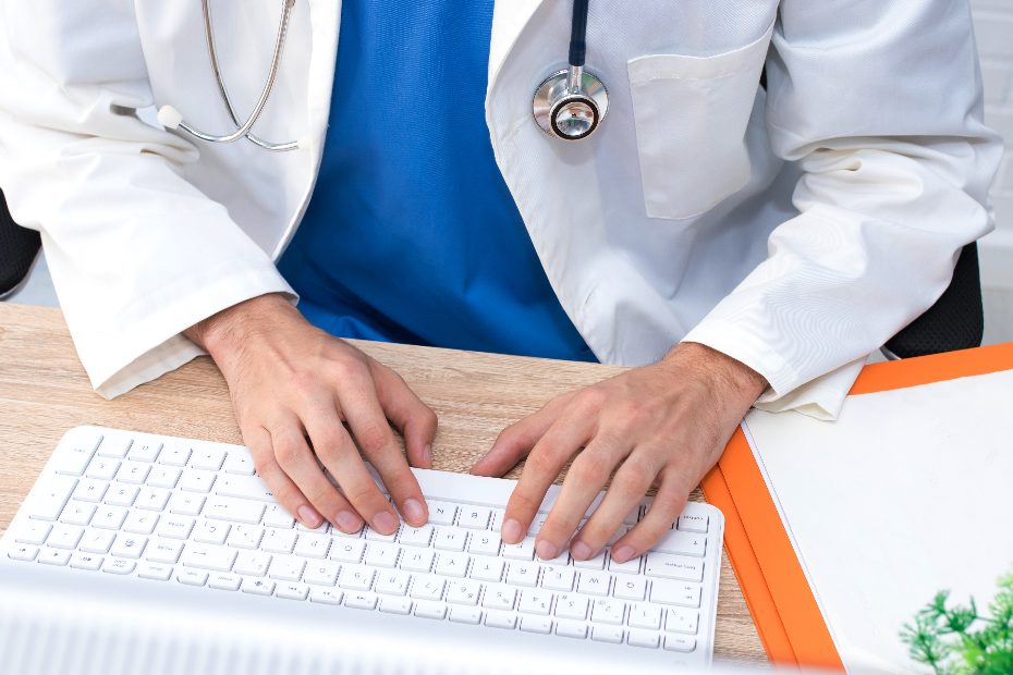 Les mains du médecin tapant sur un clavier