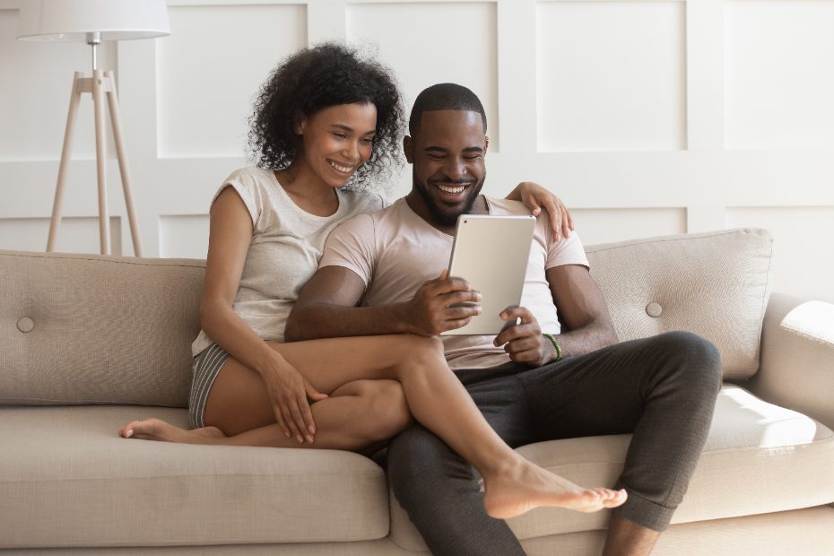 Un couple assis sur le canapé avec une tablette