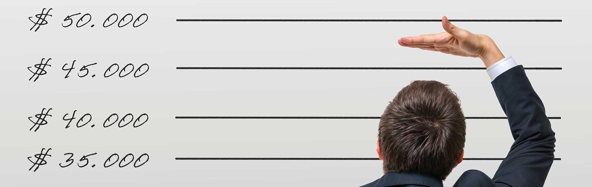 Un homme mesure sa taille devant un mur.